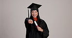 Certificate, graduation and pointing with Japanese woman in studio on white background for choice or vote. Diploma, education or face of college or university student in cap and gown as graduate