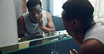 Mirror, skincare and washing face with black man in bathroom of home for morning routine. Cleaning, face and hygiene with reflection of African person in apartment for daily grooming or hydration