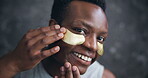 Face, black man and smile with eye mask for skincare, hygiene and glow in dark background. Male person, facial patches and happy or satisfied with cosmetics product for self care and grooming