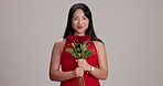 Happy, face and woman with roses in studio for valentines day, anniversary or romantic gift. Smile, present and portrait of Japanese female person smelling bouquet of red flowers by gray background.