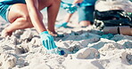 Volunteer, trash and hands of person at beach for recycling, environment cleaning and social responsibility. Community service, pollution and waste disposal with closeup of people for climate change