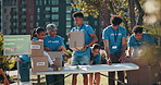 Team, volunteering or outdoor with boxes for charity, donation drive or community service. NGO people, package or checklist in city for social responsibility, distribution or food supply for poverty