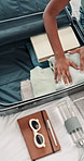 Hands, woman and packing suitcase at house for travel preparation, clothes and organising of vacation. Above, female person and wardrobe in luggage, hospitality and holiday trip of abroad destination