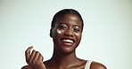 Face, cream and black woman with dermatology, cosmetics and shine on white studio background. Portrait, African person or model with lotion, aesthetic and skincare with treatment for acne or wellness