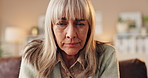 Senior, sad woman or depression with bad news, rejection or emotion on sofa at home. Elderly, female person or worry with concern or illness for cancer, diagnosis or life expectancy on couch at house