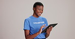 Volunteer, woman and tablet in studio for smile, scroll or review for charity drive by white background. African girl, person and excited on touchscreen, app or check progress with donation checklist