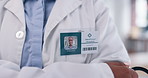 Name tag, healthcare and doctor in hospital with crossed arms for confidence in medical service. Pride, closeup and professional medical worker with badge for career with stethoscope in clinic.
