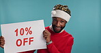 Christmas, man or sale poster in studio for holiday savings, festive deal or discount on promotion offer. Advertising, happy black person or portrait with sign for bargain purchase on blue background