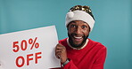 Surprise, man or board with christmas sale for holiday savings, festive deal or half price on promotion offer. Advertising, black person or portrait with discount sign for profit on studio background
