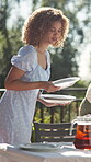 Dishes, outdoor or happy woman setting table for party, event and celebration gathering in home. Christmas lunch, smile and preparation for dinner, meal prep and serving plates for catering decor