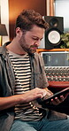 Man, tablet or music producer in studio for research, networking or planning for production. Musician, tech or typing in recording room for song writing, creativity or social media post for followers