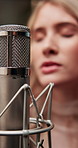 Microphone, singing and artist in studio for audio production, creative performance or gear. Music, professional musician or equipment for recording sound, jazz song and woman broadcast voice closeup