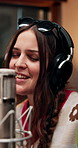 Headphones, woman singing and musician in recording studio for audio production, creative performance or talent. Music artist, microphone and professional with sound, pop or broadcast voice for album