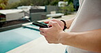 Man, hands and phone for typing at hotel pool, chat and vacation for message communication. Male person, social media scroll and surfing hospitality service at luxury resort, text and travel lodge