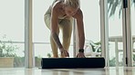 Fitness, yoga mat and and woman getting ready in home or studio fitness, holistic wellness and exercise gear. Pilates, workout and young person start training for zen, meditation or spiritual healing