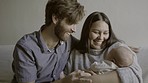 Happy mother and father with a baby on the sofa for love, care and comfort. Smile, home and a new family holding a newborn child for bonding as a parent in the living room together