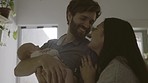 Happy mother and father with a baby for love, care and comfort. Smile, home and a new family holding a newborn child for bonding as a parent in the living room together