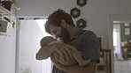 Father with baby, love and family bonding for relationship, hug and cuddle child at home. Man rock newborn to sleep, new dad and affection with care in living room