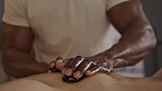 Stones, hands and therapist doing a back massage at a spa for luxury self care, healing and wellness. Health, relax and closeup of masseuse doing a natural body treatment with hot rocks at a salon.