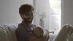 Happy, care and a father with a baby on the sofa for love, nurturing and comfort. Calm, home and a new father holding a newborn child for bonding as a parent in the living room together