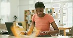 Tablet, laptop and business woman in the office doing research for creative project on internet. Digital technology, career and young African female designer working on computer in modern workplace.