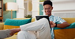 Search, smile and tablet with man on sofa for online reading, communication and social media post. Networking update, contact and streaming with person in living room at home for app and scroll
