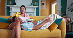 Happy couple, laughing and watching tv with fruit on sofa for movie, entertainment or comedy show at home. Man, woman or lovers with smile for online streaming, series or bonding together at house