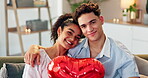 Couple, face and heart balloon in home for valentines day, romantic gift and present for relationship. Love, people and bonding together on sofa for celebration, commitment and loyalty with support