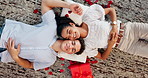 Romance, couple and rose petals with gift on floor for valentines day decor, anniversary date or connection. Above, people and talking on honeymoon for bonding together, happy or celebration of love
