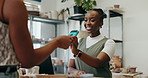 Happy woman, cashier and customer with pos machine for payment, transaction or tap to buy at ceramic store. Female person, shopper and paying with credit card or NFC for pottery shopping or purchase