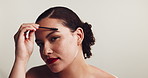 Woman, face and eyebrow in studio with mascara brush, shape and makeup for facial transformation by white background. Girl, model and person with tools, cosmetics and portrait for results in Mexico