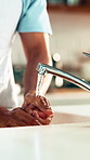 Person, washing hands and dry with tap water for cleaning, bacteria or germ removal in kitchen at home. Closeup, liquid or rinse with faucet and cloth in sink for hygiene or disinfection at house