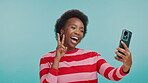 Woman, happy and peace sign with selfie in studio for social media post, blowing kiss and profile picture update. Laugh, black person and live streaming video for funny face memory on blue background