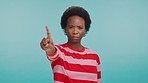 No, gesture and face of black woman in studio with anger, disappointment and advice in caution. Compliance, warning and frustrated person with stop hand sign for wrong decision on blue background