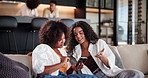 House, smartphone and women on sofa, funny and conversation with online reading in lounge. Apartment, happy people and girls on couch, cellphone and mobile app for social media, smile and connection