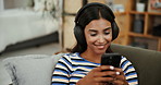 Mobile, music and happy woman relax with headphones in home for edm album, video and listening to radio. Phone, online audio and girl on sofa to scroll app, streaming service or typing social media