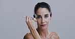 Makeup, brush and face of mature woman on gray background for wellness, skincare and beauty. Cosmetology, salon and portrait of person with tools for cosmetics, facial and spa products in studio