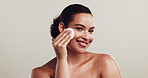Skincare, smile and woman with cotton, studio and cleansing of face for exfoliation, happy and space. White background, beauty and dermatology for healthy skin, cosmetics and person with product