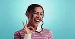 Woman, face and okay sign by studio, approval wink and student for registration motivation at college. Playful, portrait and emoji for education promotion on blue background, support and feedback