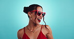 Studio, woman and excited with sunglasses for fashion, love expression and dress for valentines day. Mockup space, model and happy with heart accessory for date celebration, vibe and blue background