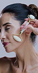 Face, jade roller and relax with mature woman in studio for morning cosmetics or skincare routine. Antiaging, massage and wrinkles with person on white background for dermatology or natural beauty