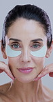 Beauty, woman and face skincare with eye patches for hydration, firm skin treatment or rejuvenation. Routine, person or cosmetics product for dark circles, wellness or anti aging on studio background