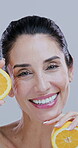 Woman, happy and orange at face for skincare, natural treatment or vitamin C in studio. Mature person, citrus fruit or laugh on white background space with organic care, healthy skin or antioxidants