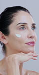 Face cream, beauty and mature woman for skincare, wellness and facial care on white background. Dermatology, spa and person with lotion for anti aging, collagen and cosmetics products in studio