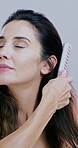 Haircare, beauty and woman brush hair on studio background for scalp stimulation, growth and stress relief. Person, cosmetic product and grooming for smooth texture, maintenance or collagen treatment
