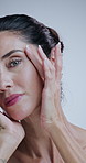 Woman, skincare and face with dermatology in studio with beauty, check and touch for results by background. Mature person, model and portrait for cosmetics, glow or anti aging transformation in Italy