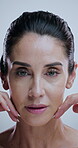 Hands, woman and face in studio for skincare, treatment and collagen benefits for anti aging. Portrait, beauty model and mature person with confidence for cosmetics, glowing skin and white background