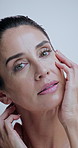 Skincare, touch and face of woman in studio for anti aging, cosmetics and wrinkle treatment. Dermatology, mature and portrait of person for beauty, wellness and glow of natural texture on background