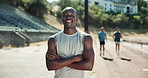 Arms crossed, black man and athlete with pride, outdoor and health for endurance, workout and track field. Runner, stadium and confident guy for wellness training, exercise or fitness portrait