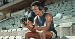 Music, phone and runner with man in stadium for streaming, workout playlist and competition practice. Marathon training, radio and headphones with person in arena for sports athlete, fitness or audio
